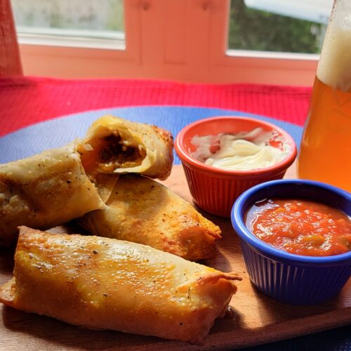 Taco eggrolls with sour cream and salsa dip